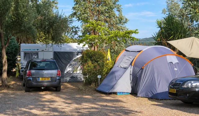 Ein Wohnwagen und ein Zelt auf den Terrassen des Campingplatzes